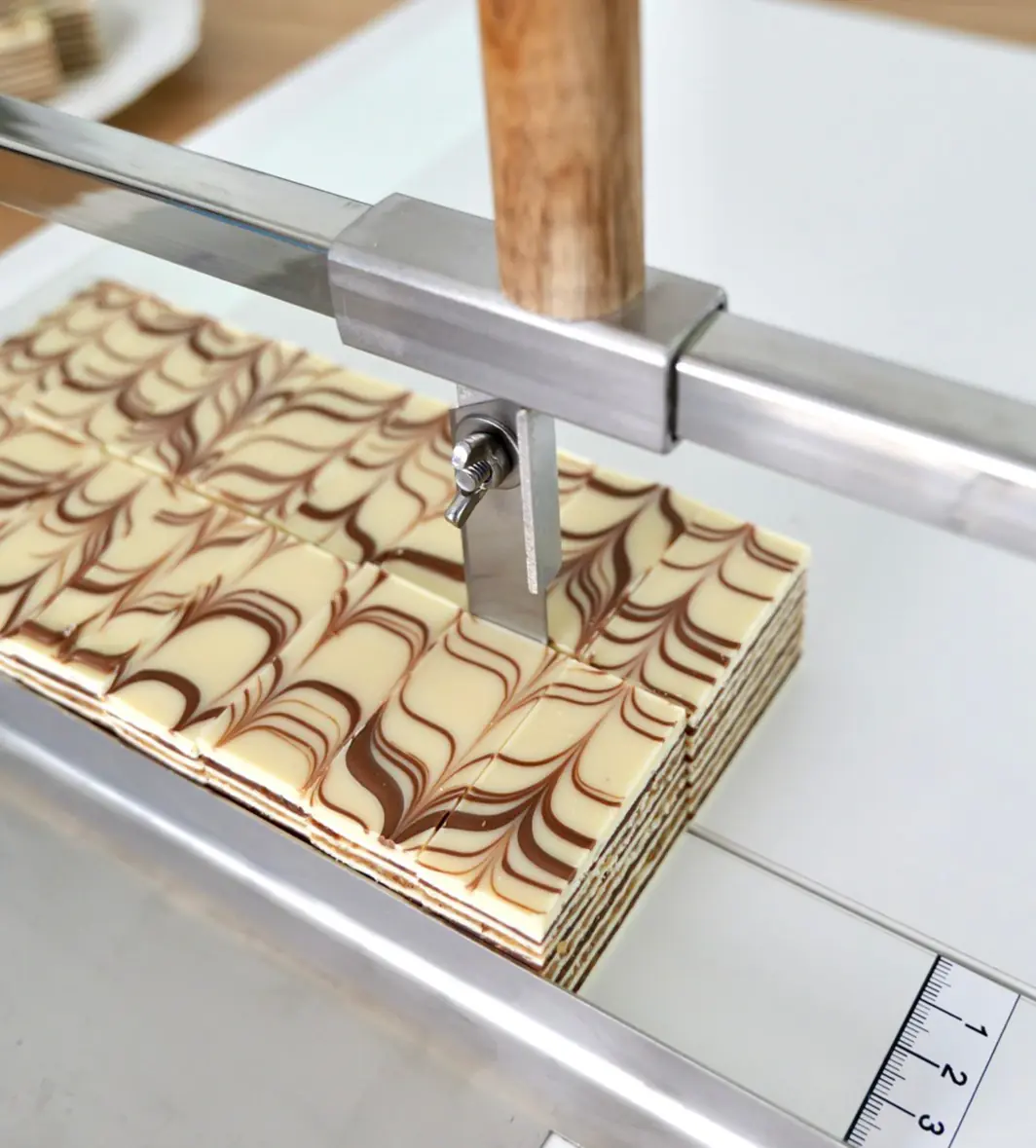 Bajadera kolač isečen profesionalnom mašinom za sečenje kolača - seckalica za kolače sa nožem od inoxa